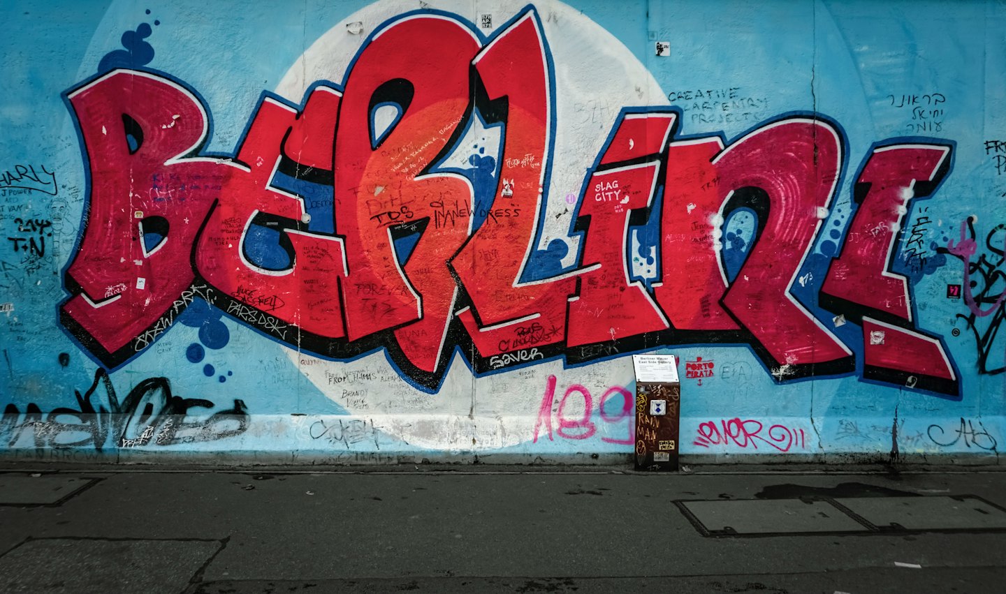 Graffiti-Wand mit Berlin in großen roten und blauen Buchstaben.